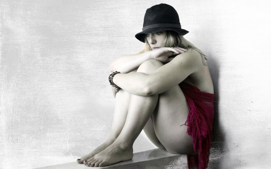 Девушка в шляпе сидит ню